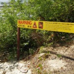 Living With Port Douglas Crocodiles. Salties in Port. Crocodile warning sign on the beach in Port Douglas