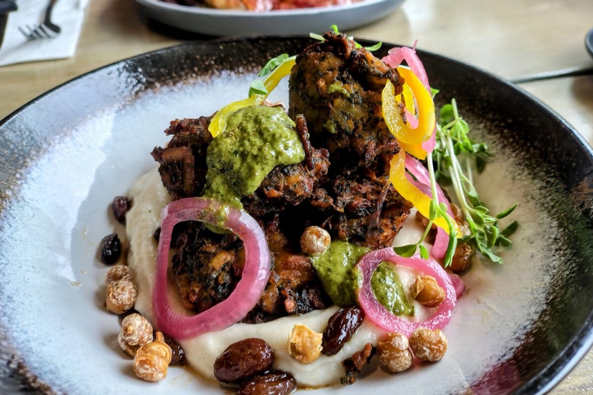 Vegan breakfast plate, puree pakoras spicy chick peas and pickled onion slices dressed with pesto.