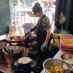 Eating At Jay Fai Bangkok Jay Fai, the cook, cooking at a small gas stove in her Bangkok restaurant.