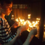 tourist children lighting candles at a temple in nepal